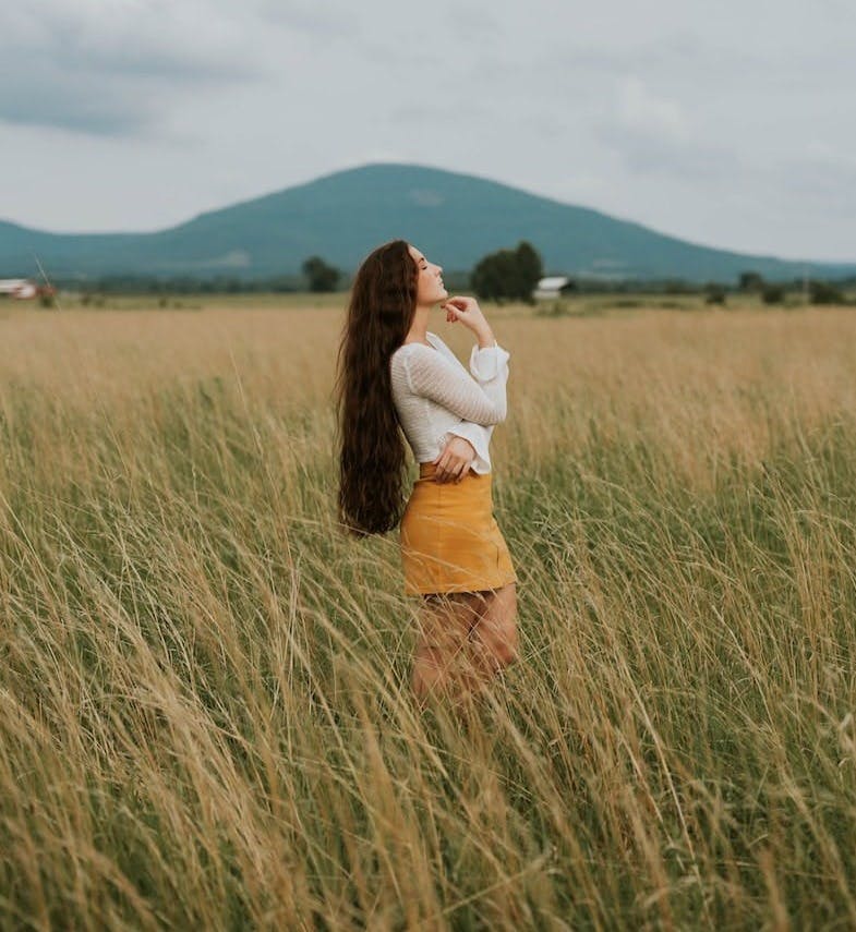 woman standing in the middle of grass field