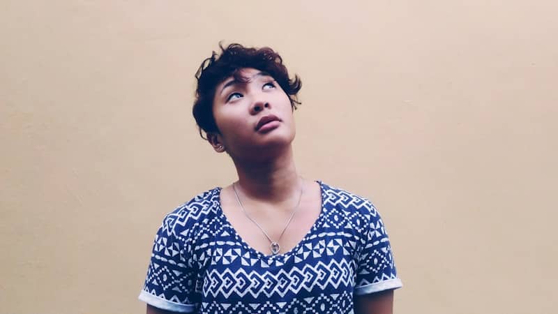 woman wearing black and white shirt looking above