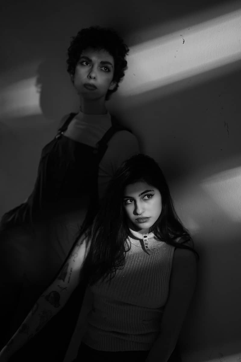 Two women pose, captured in dramatic black and white.