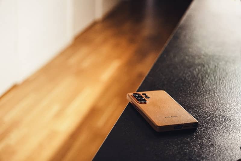 A smartphone lies on a dark surface.