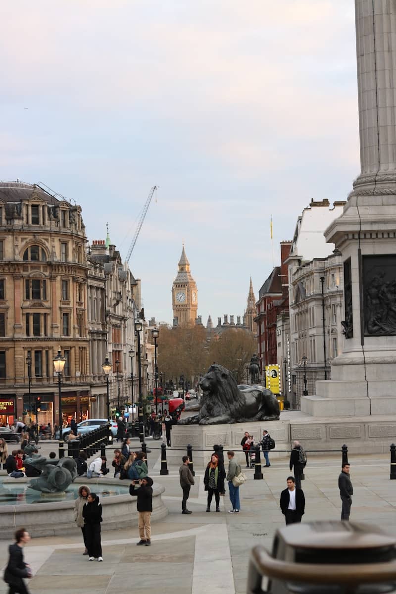 Trafalgar square with nelson's column, lion statues, and big ben.