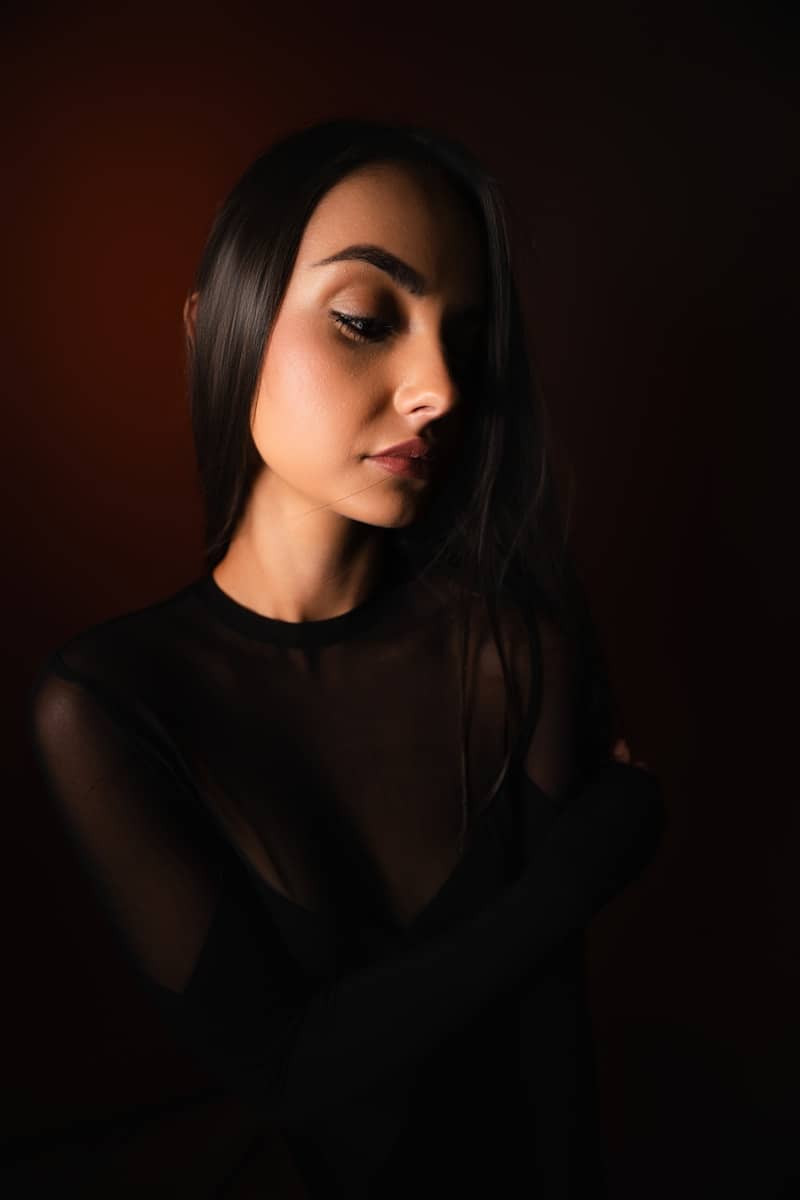 Young woman with dark hair looking down