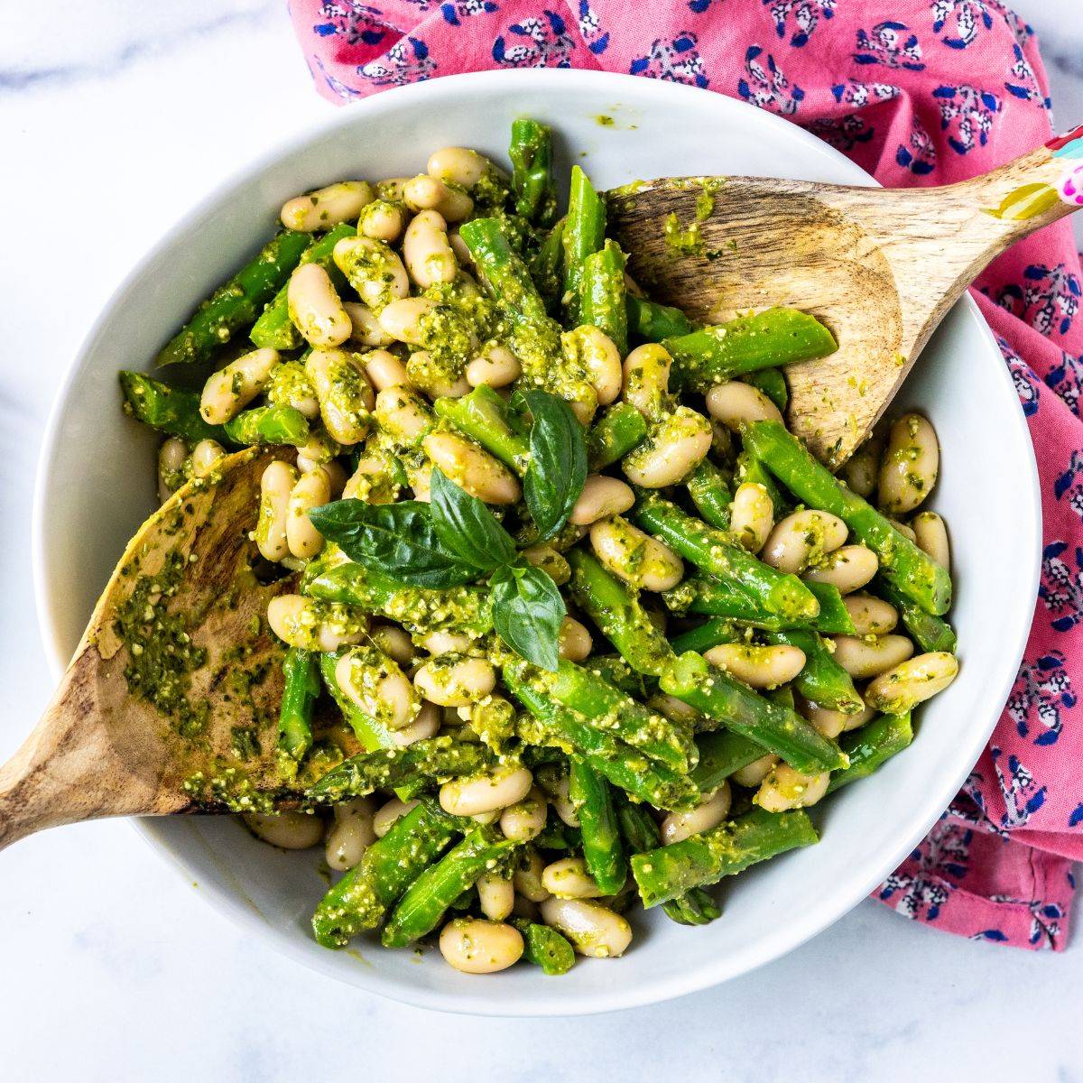 Bowl of asparagus white bean salad tossed in lemon pesto dressing.