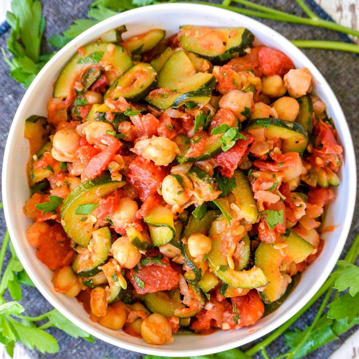 Bowl of stewed zucchini and tomatoes with chickpeas.