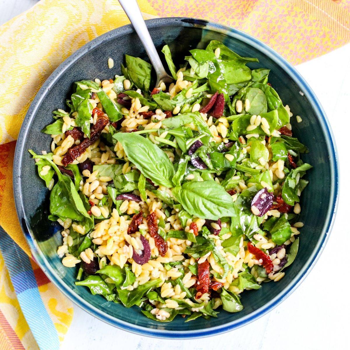 Spinach orzo salad with sun-dried tomatoes and olives.