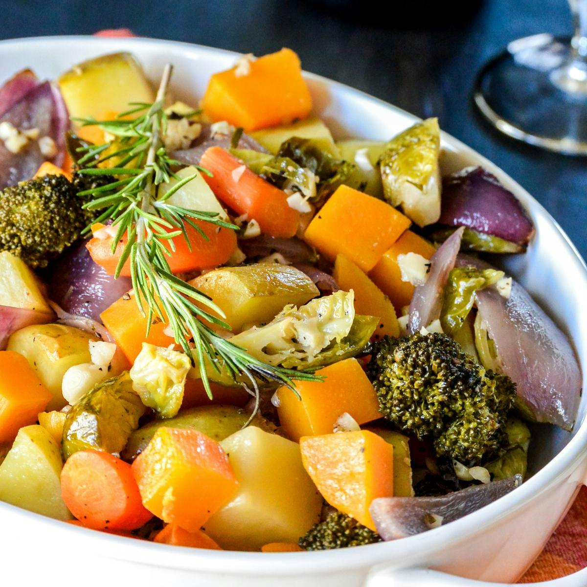 Roasted vegetables garnished with a sprig of rosemary.