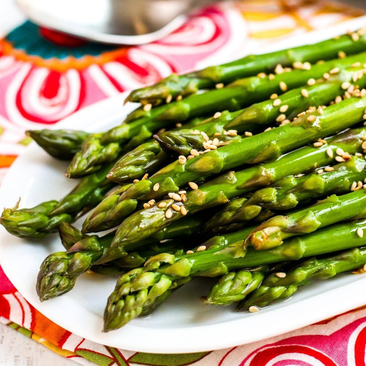 Platter of chilled marinated asparagus topped with sesame seeds.