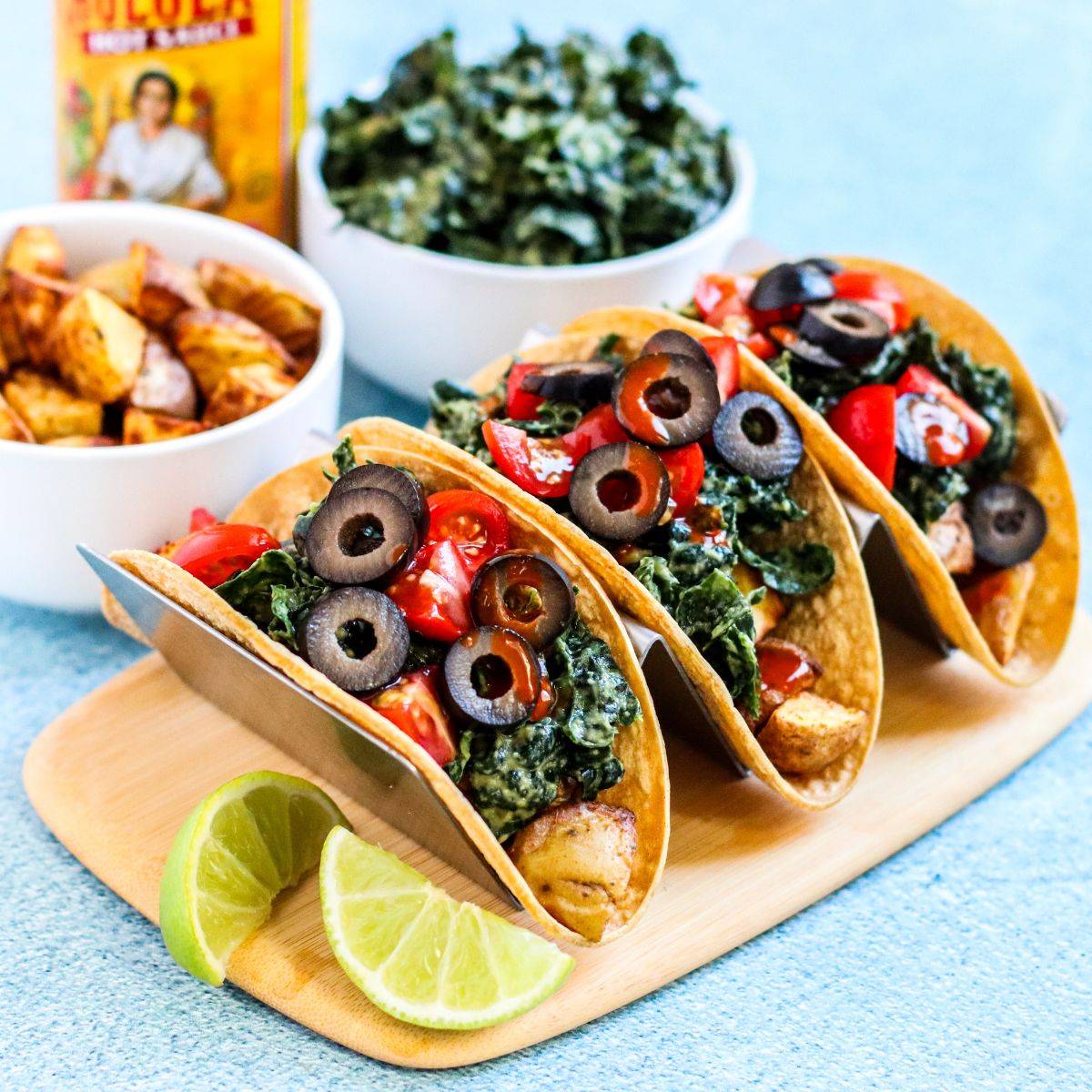 Potato tacos with avocado massaged kale, tomatoes, olives, and hot sauce.