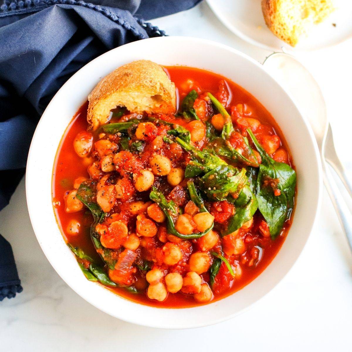 Bowl of chickpea tomato stew with spinach.