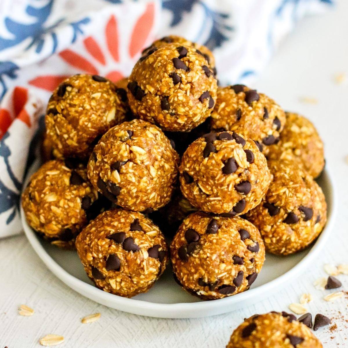 No bake pumpkin balls with mini chocolate chips on a plate.
