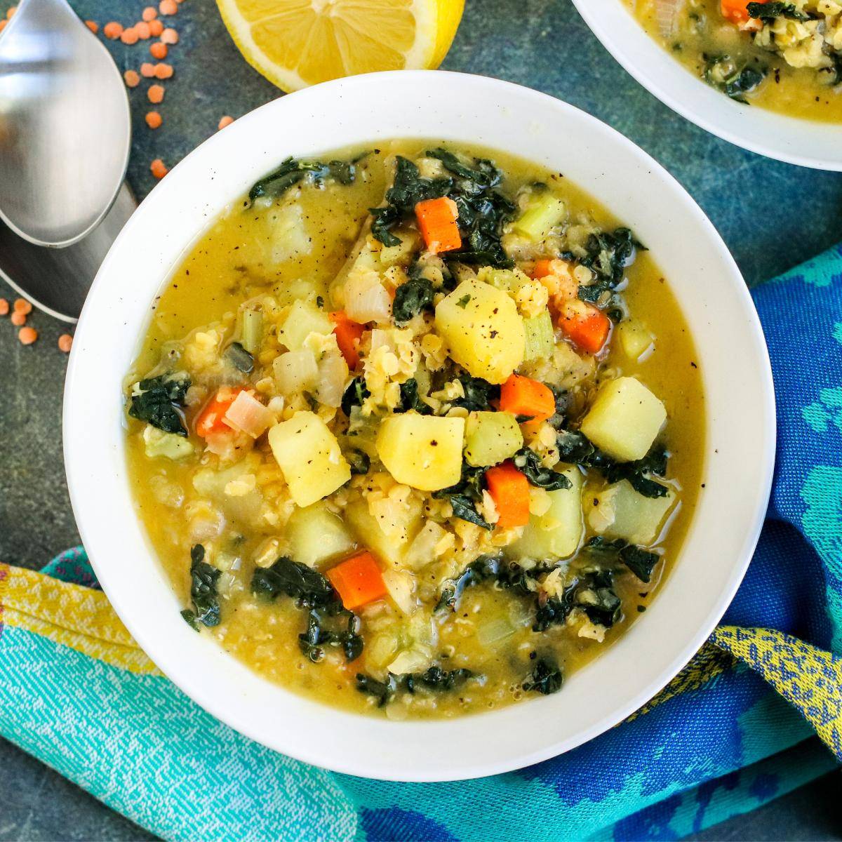 Bowl of red lentil potato soup with kale.