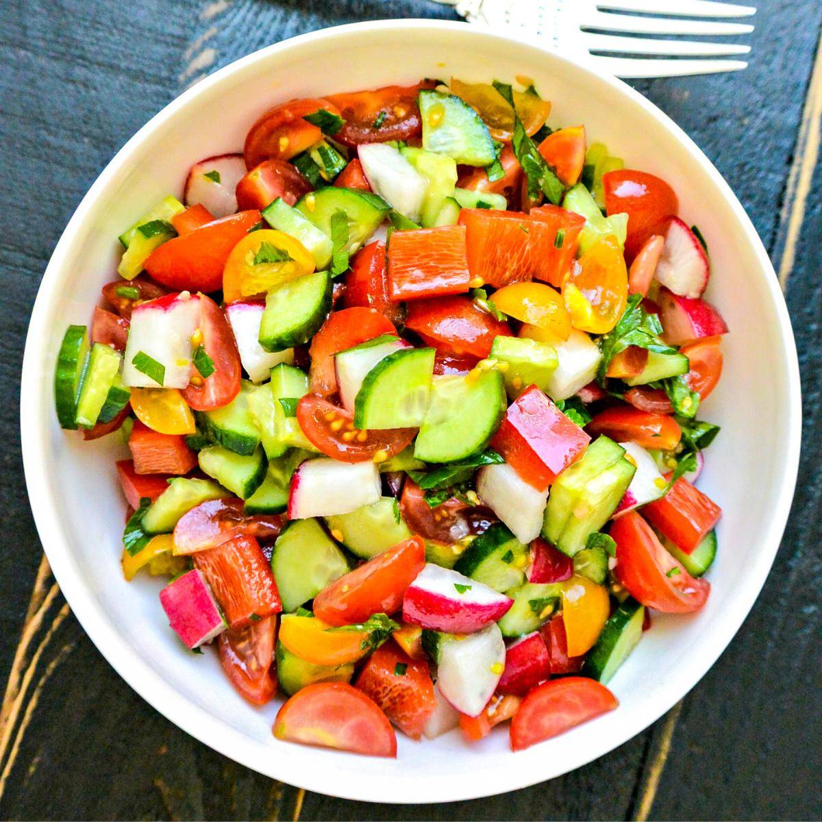Bowl of cucumber, tomato, and bell pepper salad.