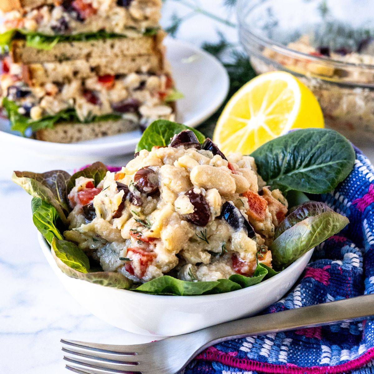 Smashed white bean salad on mixed greens and in a sandwich.