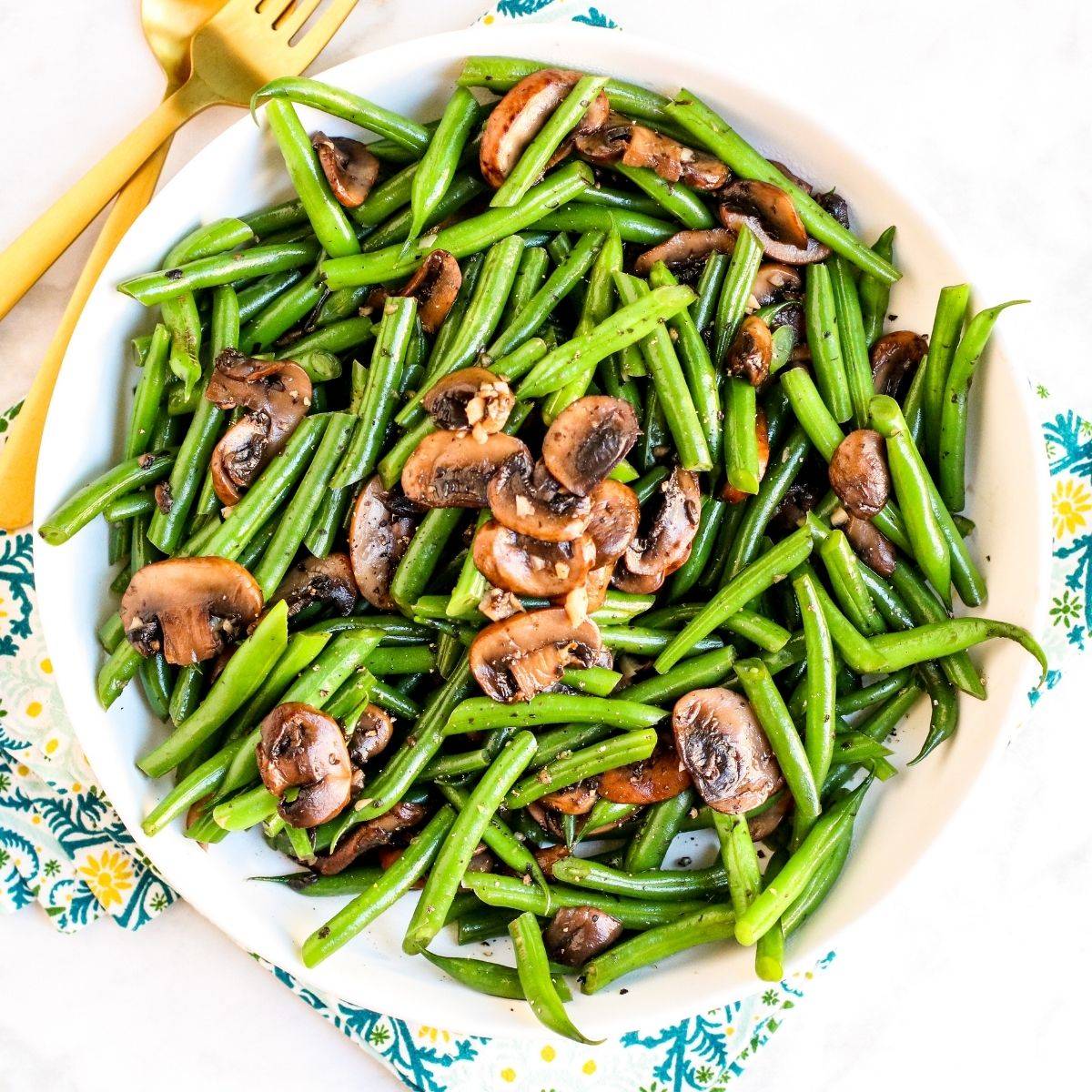 Plate of sauteed green beans and mushrooms.