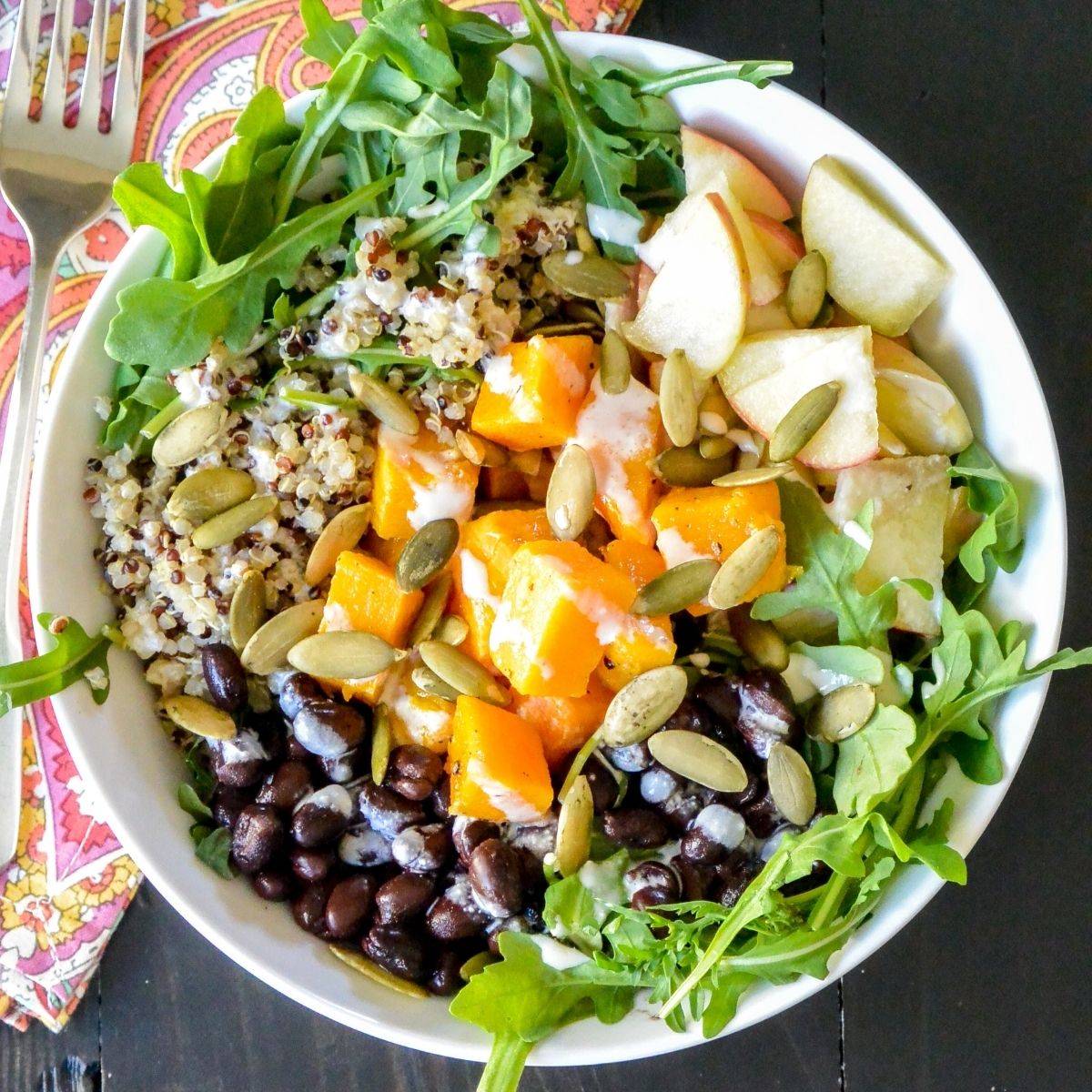 Butternut squash quinoa bowl with black beans, apples, and arugula.