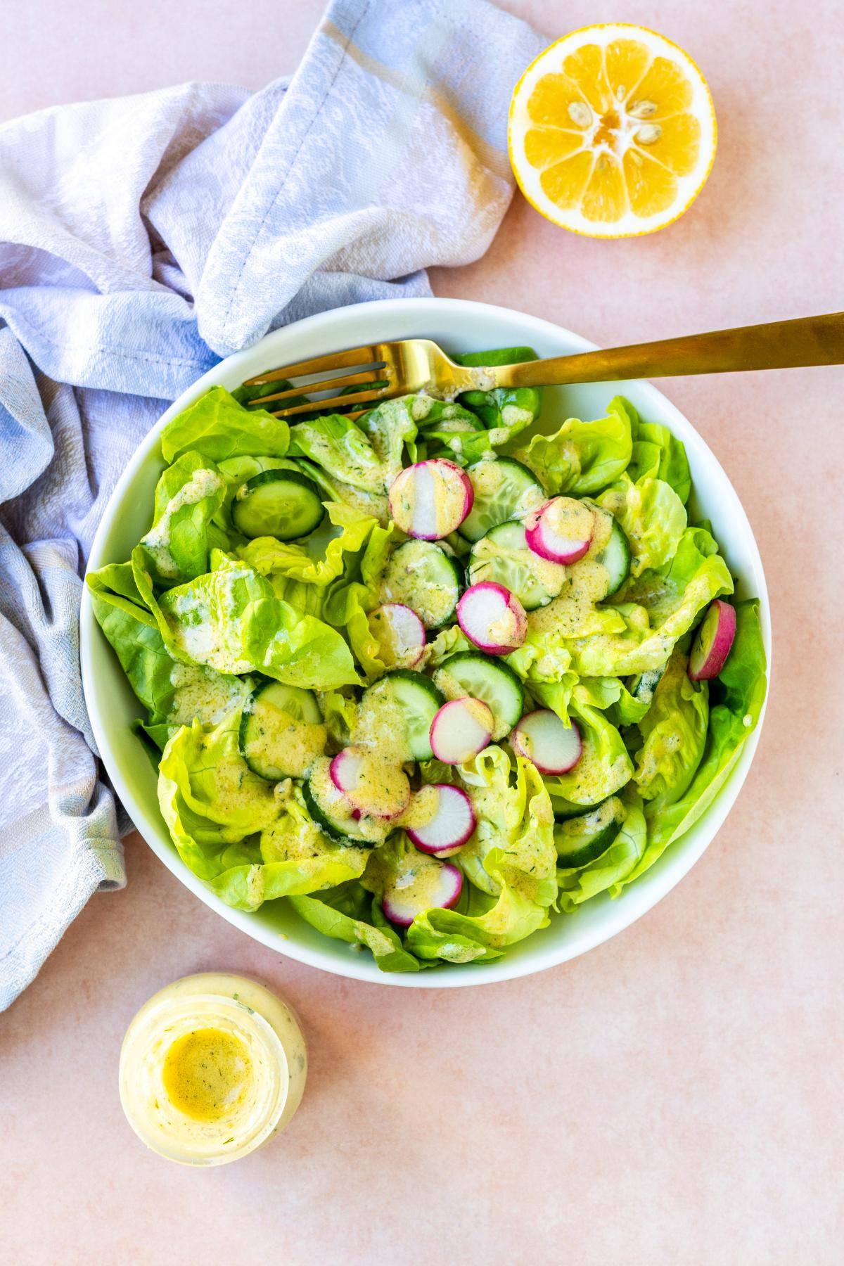 Salad drizzled with hummus dressing.