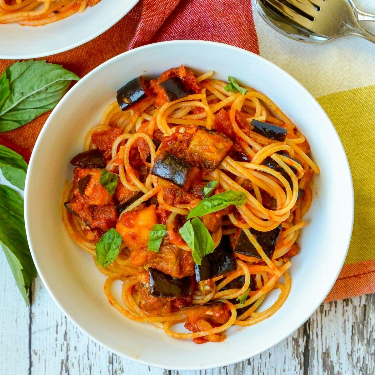 Bowl of spaghetti with roasted eggplant and tomato sauce.