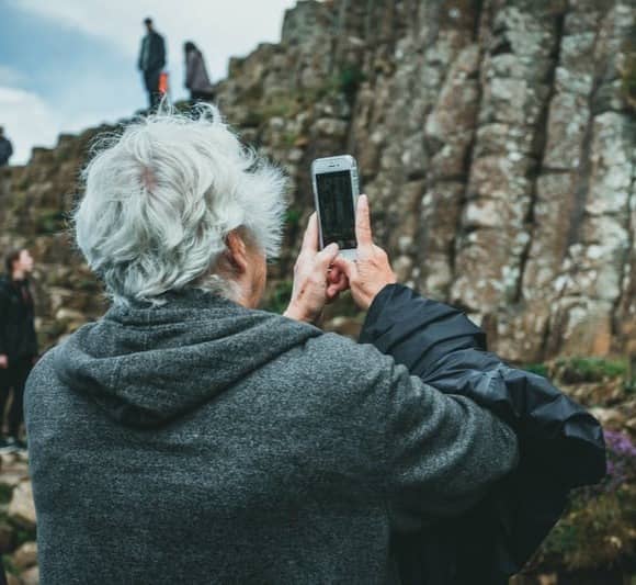 man in black hoodie holding smartphone