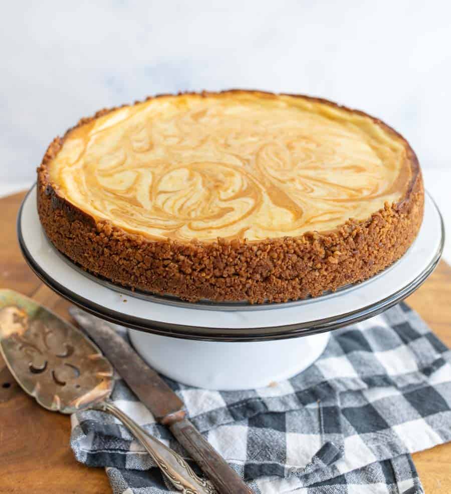 pumpkin pie on white cake stand.