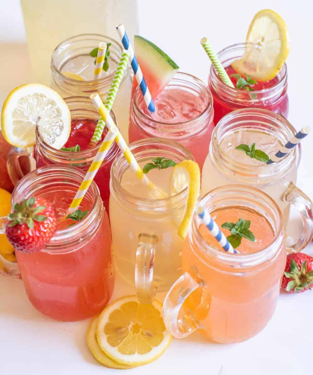 fruity lemonades in clear glasses with straws.