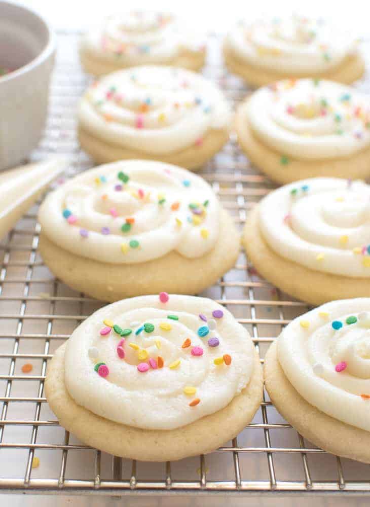 vanilla sugar cookies with white frosting and colored sprinkles.