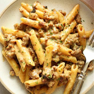 Penne with sausage on a plate.