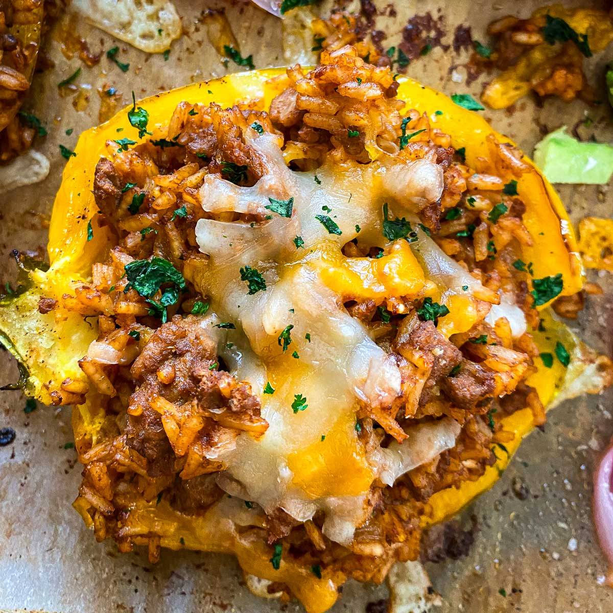 yellow pepper stuffed with ground beef and rice with melted cheese on top and sprinkled with cilantro.