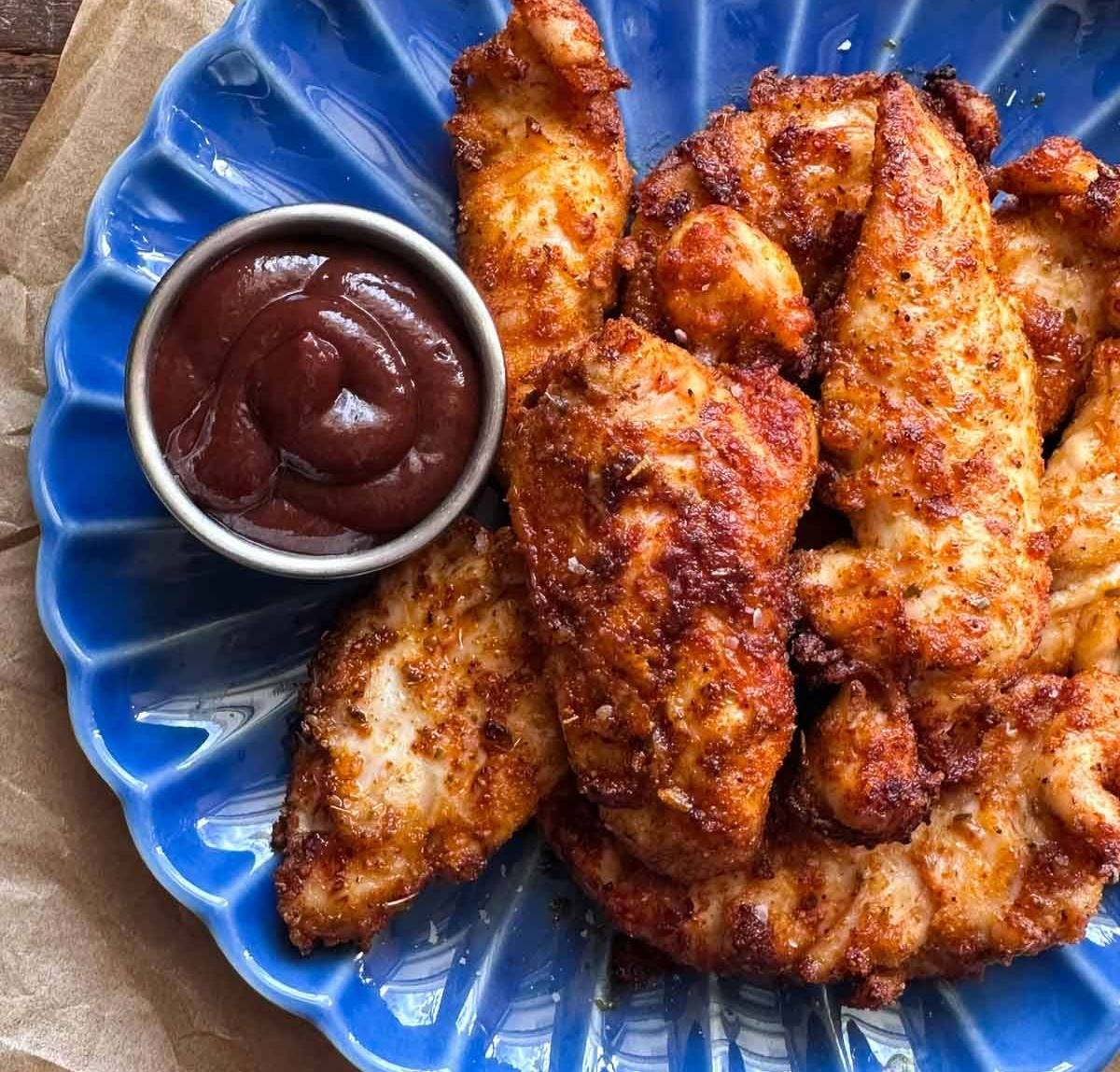 plate with chicken tenders and a small bowl of bbq sauce