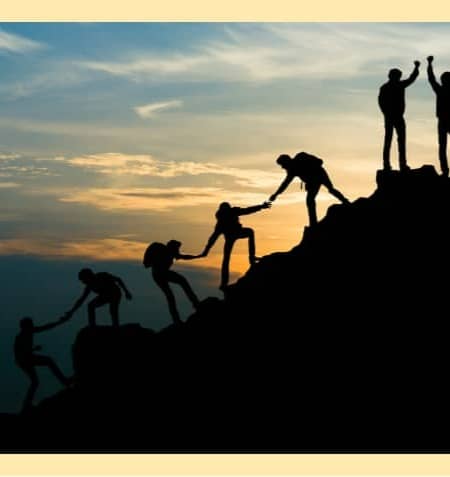 hikers connecting with one another and helping each other up a mountain