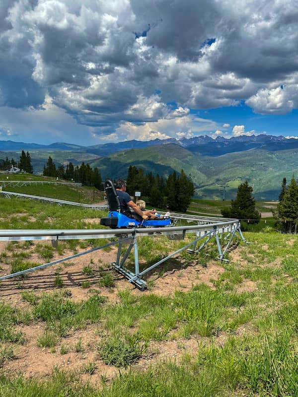 Father and son riding a mountain coaster at Epic Discovery at the top of Vail Mountain.