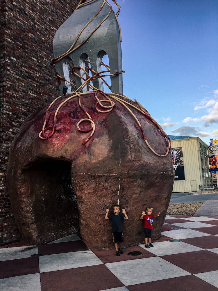 Two young boys standing under the giant spaghetti and meatball sculpture outside Pasghetti’s Restaurant along the Branson strip.