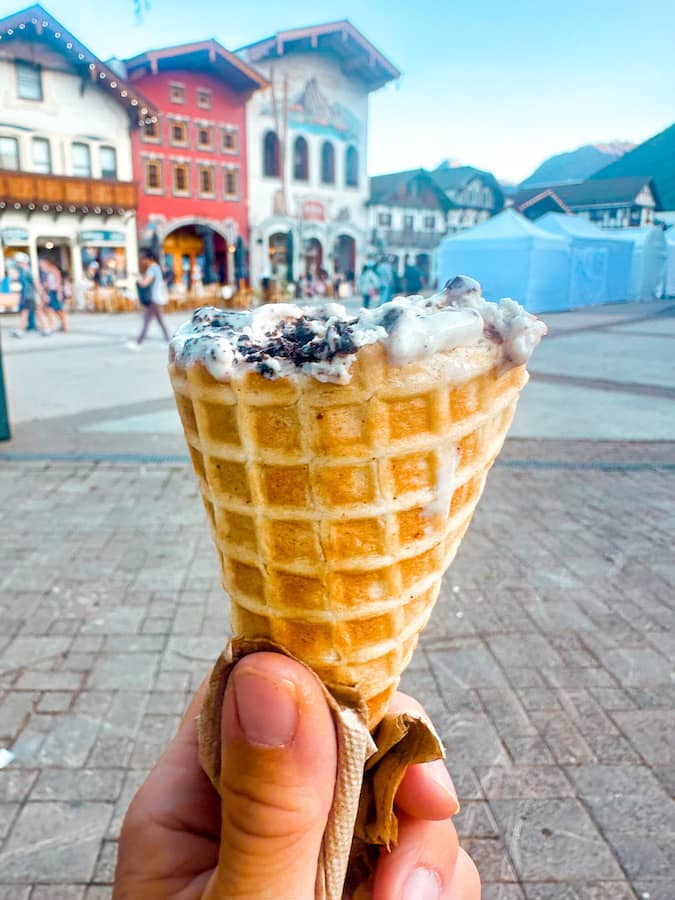 Ice cream waffle cone close-up with Leavenworth, Washington's Bavarian Village in the background.