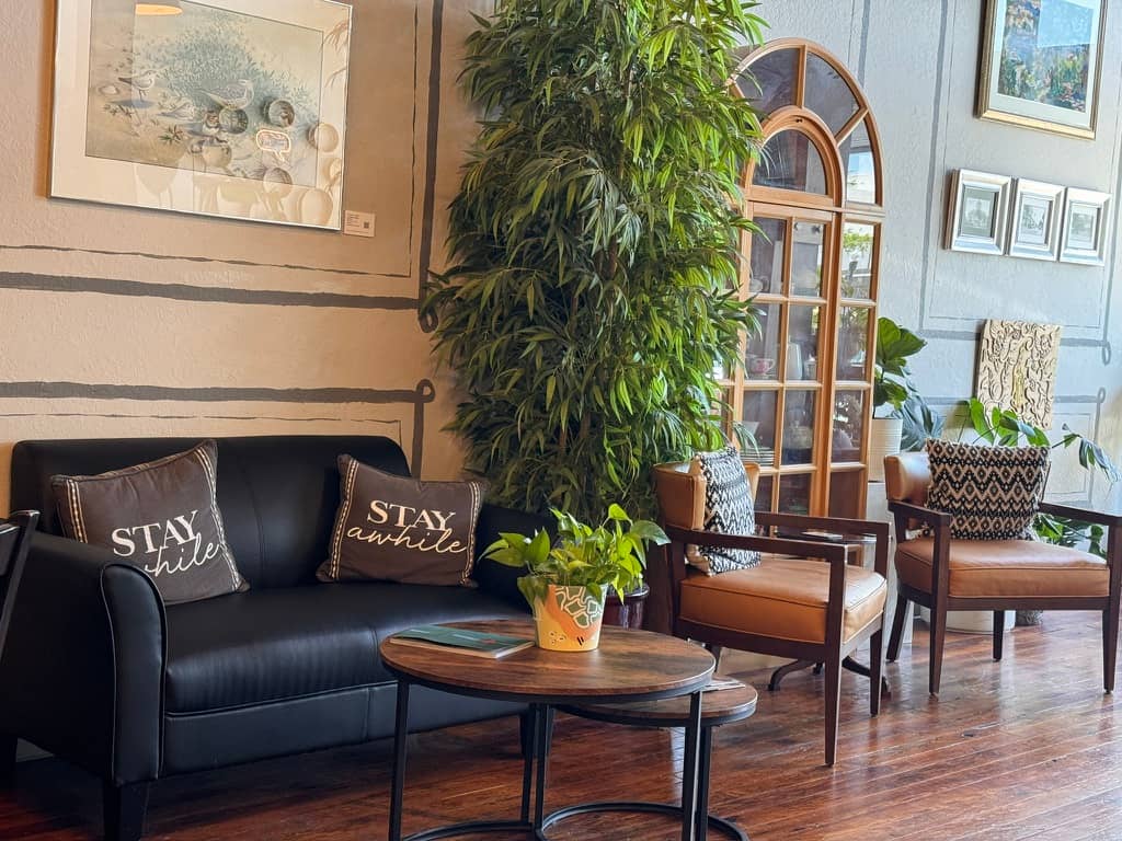 a cozy room with leather chairs, sofa and tables