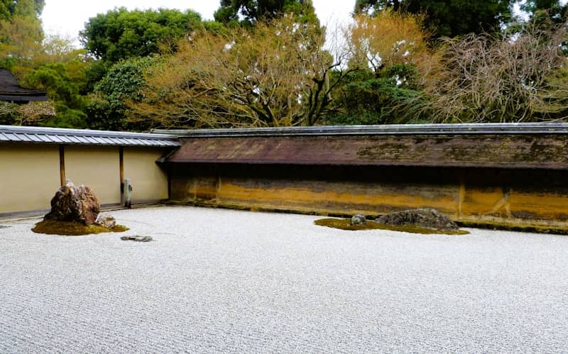A japanese rock garden with rocks and trees.
