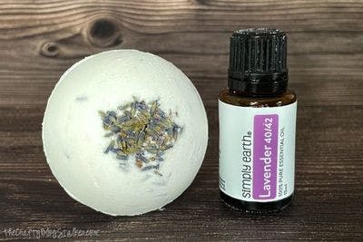 large bath bomb next to a bottle of lavender essential oils.