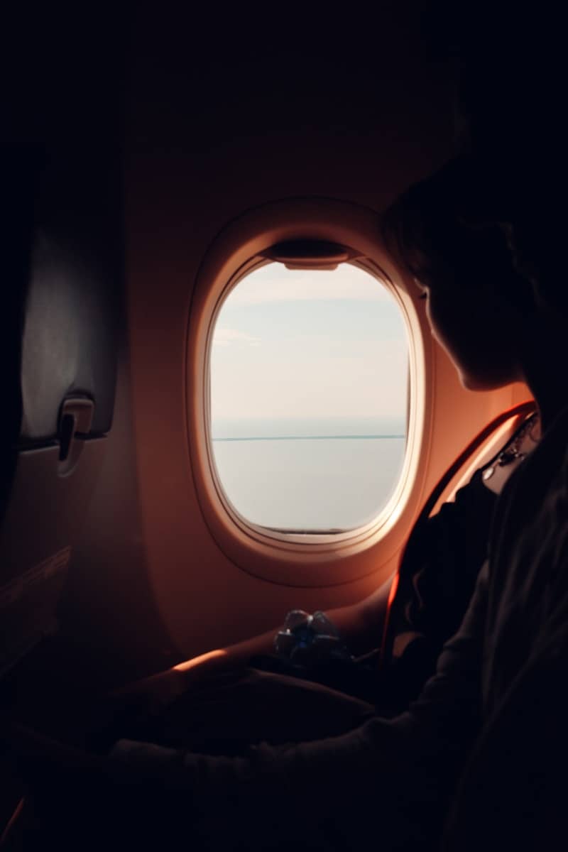 A person looks out of an airplane window.