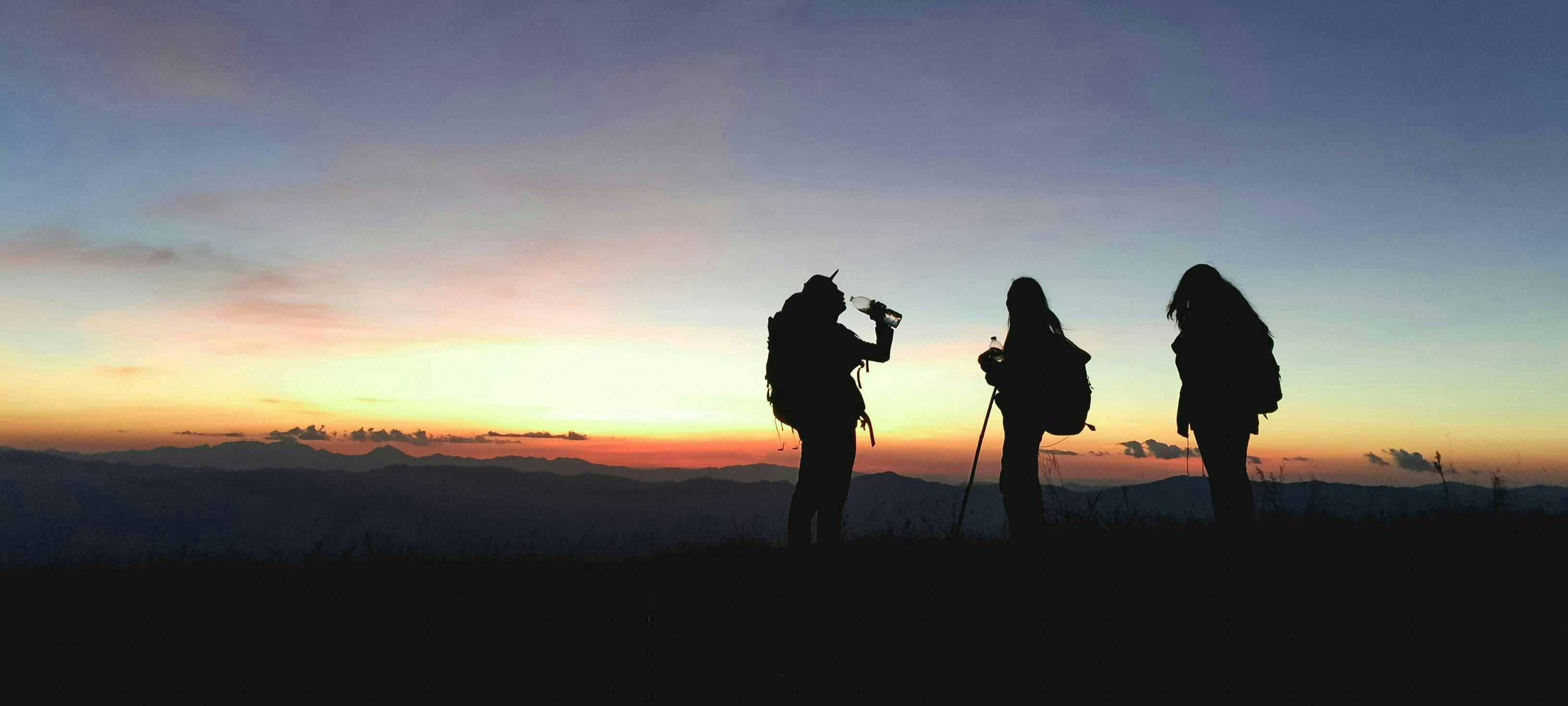 Silhouettes of three hikers in the dusk