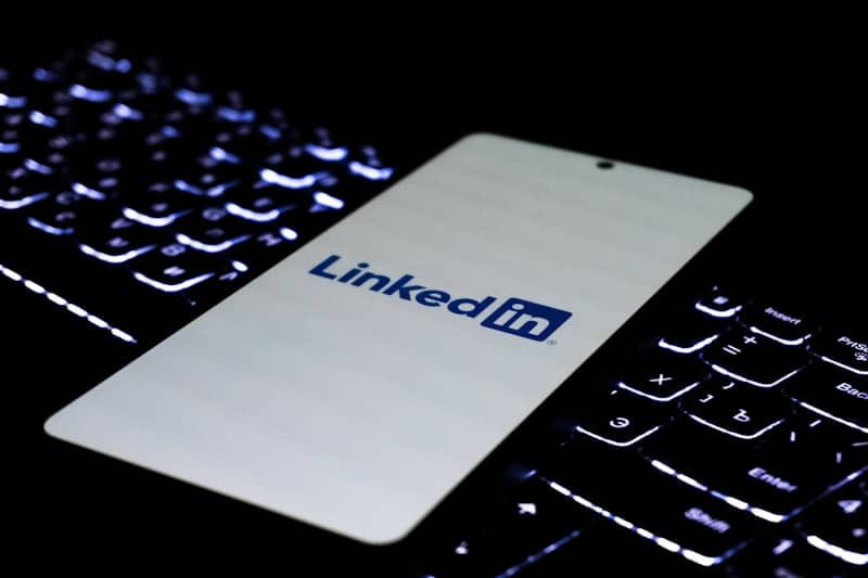 Smartphone displaying linkedin logo on illuminated keyboard