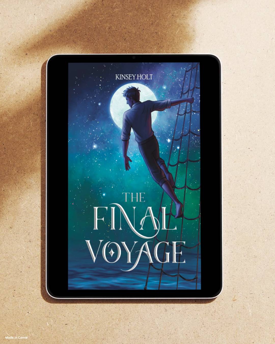 A tablet laing in sand displaying a book cover, on which is a boy standing in the rigging of a ship staring at the night sky with the words 'The Final Voyage, by Kinsey Holt'