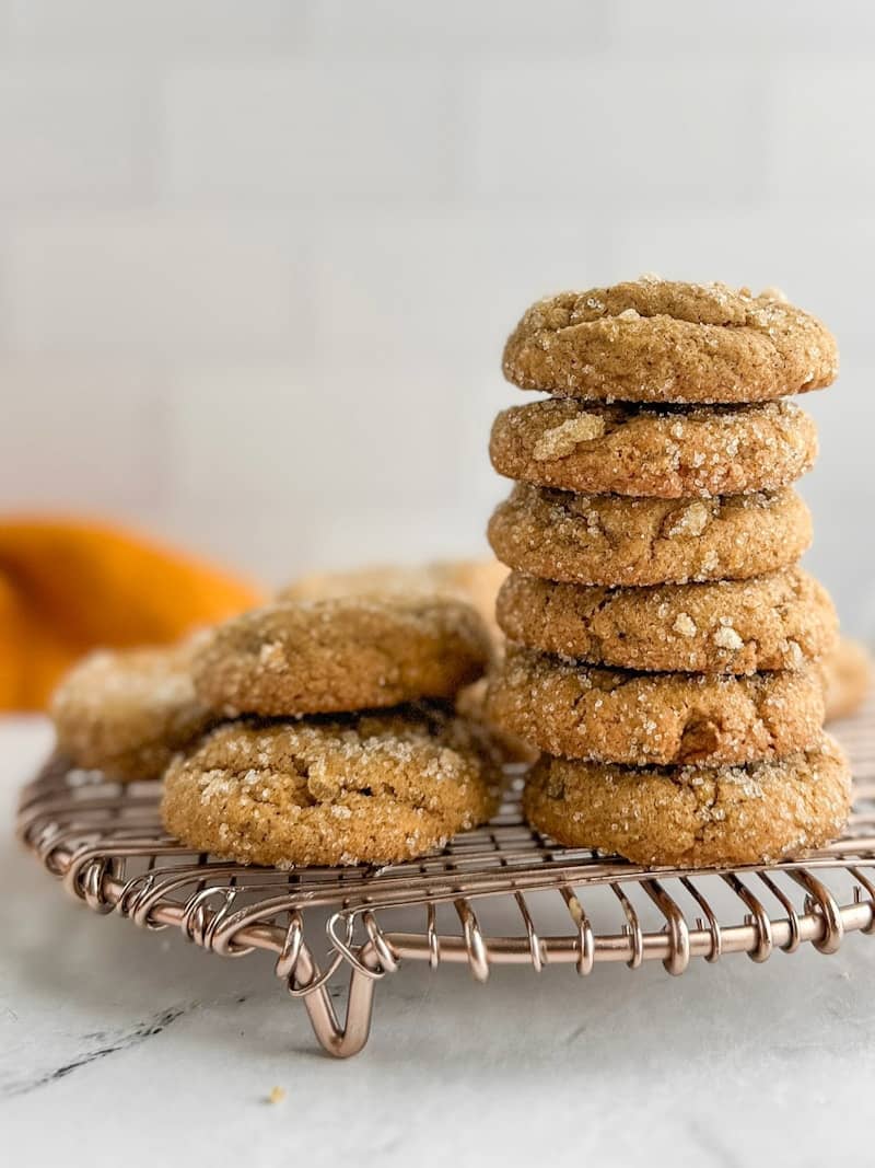 Stack of golden brown cookies on a cooling rack.