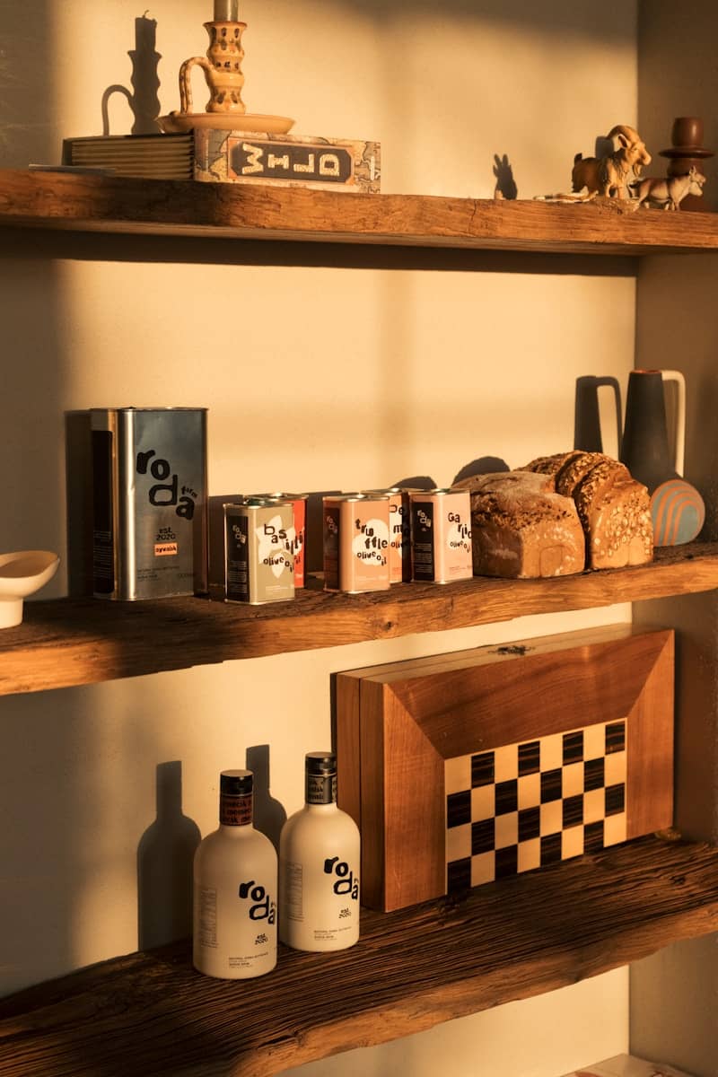 Bottles of olive oil and loaves of bread on shelves.