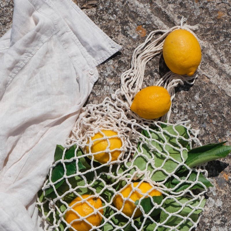 A bag of oranges and a bunch of green onions