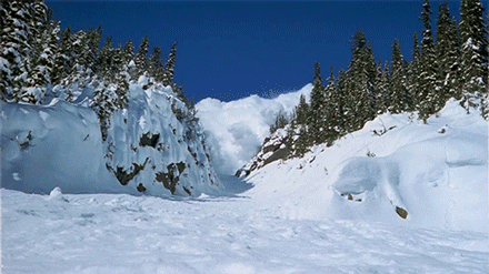 An avalanche occurring on a snowy mountain