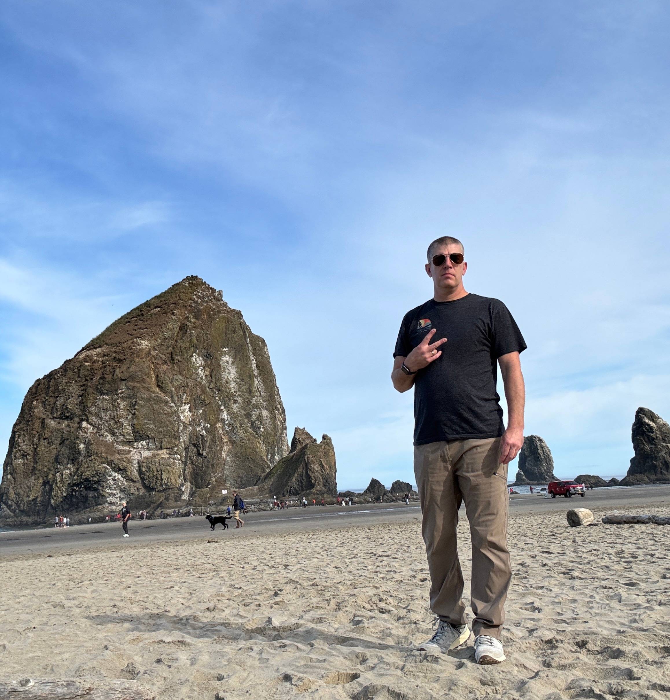 Man standing on beach in front of rock formation