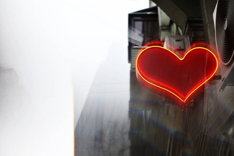 Red neon heart glowing against a misty background