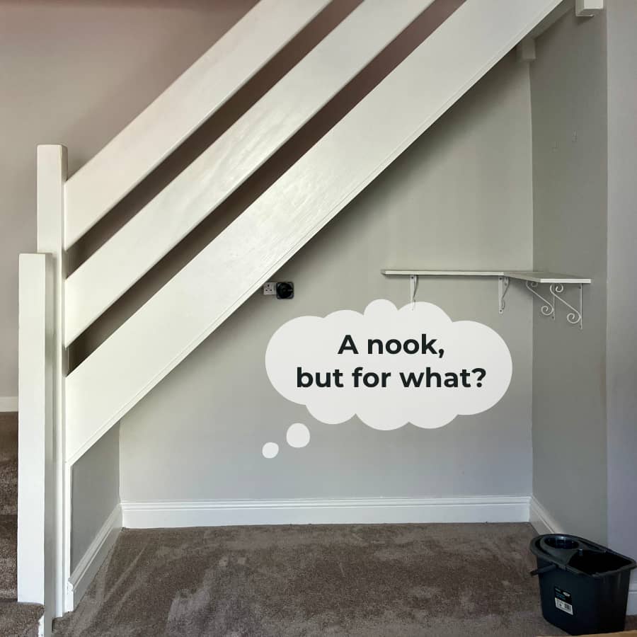 An empty nook under the stairs, in millenial grey.