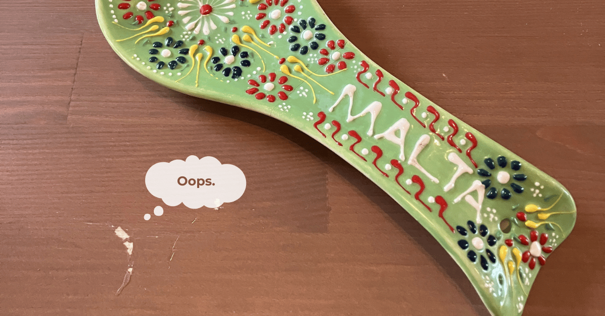 Close up of a ceramic spoon rest from Malta with a fixed crack and a damaged coffee table from the superglue.