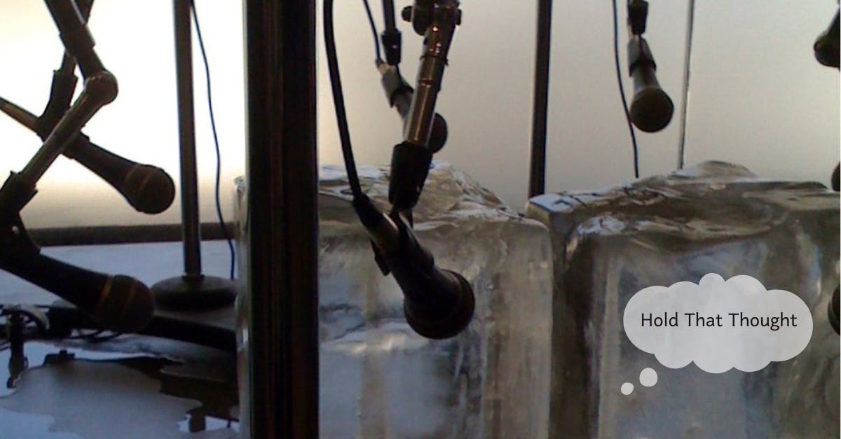Several hanging microphones are positioned around large blocks of ice.