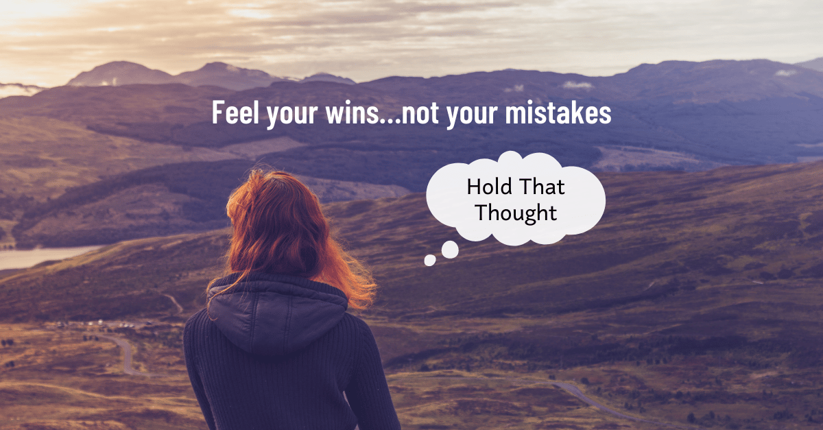 Woman sits on a mountain top at sunset, looking off to the distance. Feel your wins…not your mistakes.