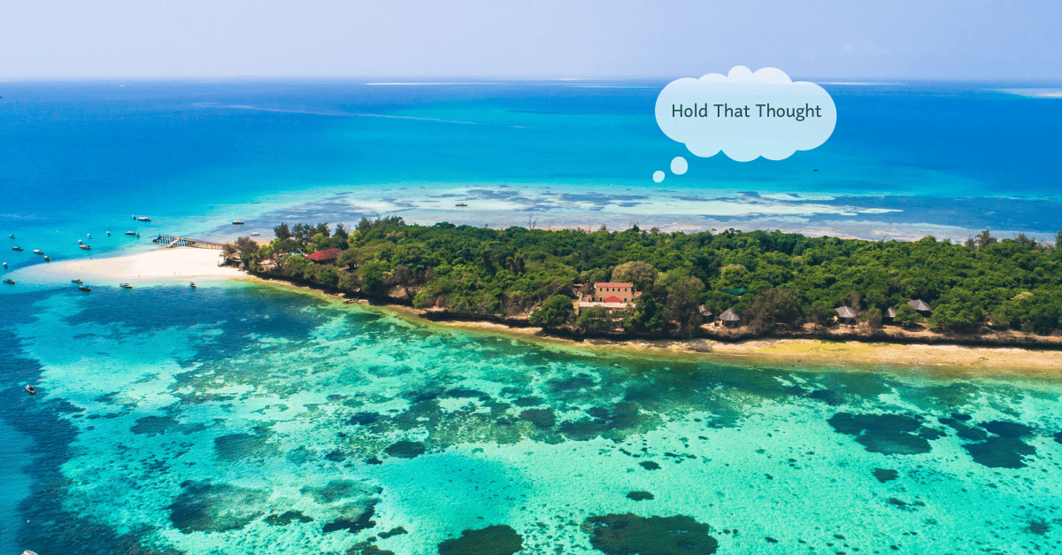 A lush island of trees with a prison located at the center, surrounded by serene blue waters.